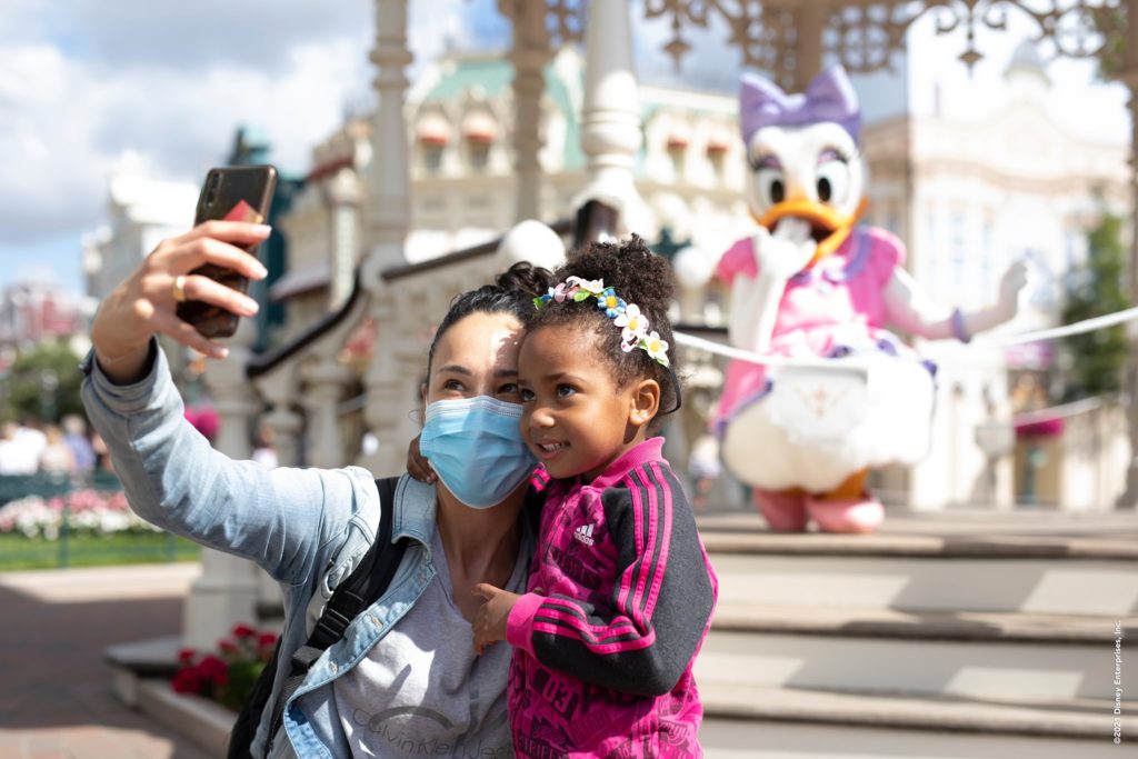 Une maman et sa fille se prennent en photo devant la scène ou est Daisy.