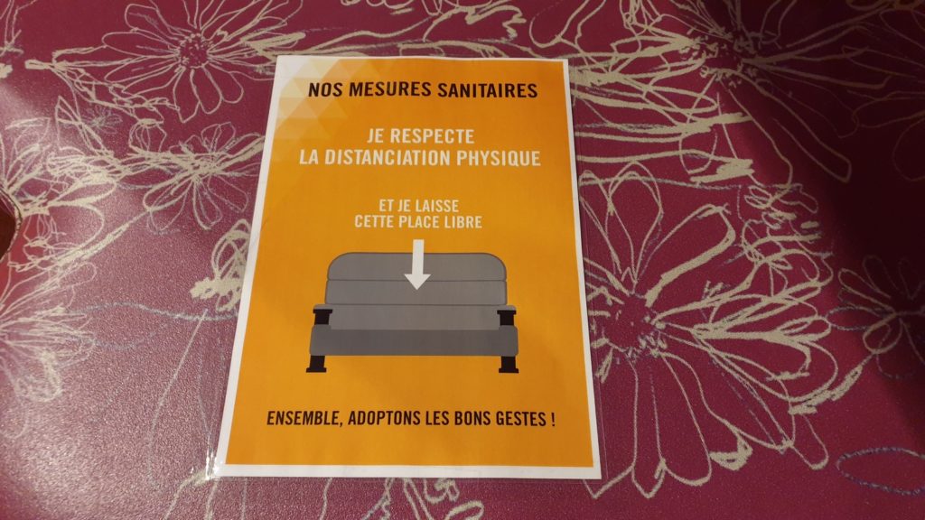 Une affiche posée sur un siège, rappelant l'obligation de ne pas utiliser cette place.