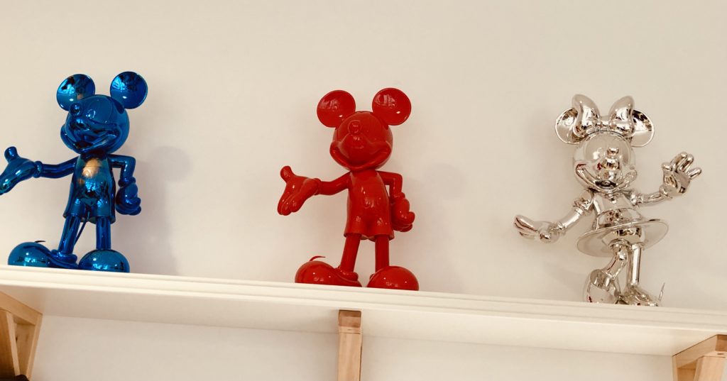 Une sculpture de mickey bleue, une rouge et une de minnie couleur argent.