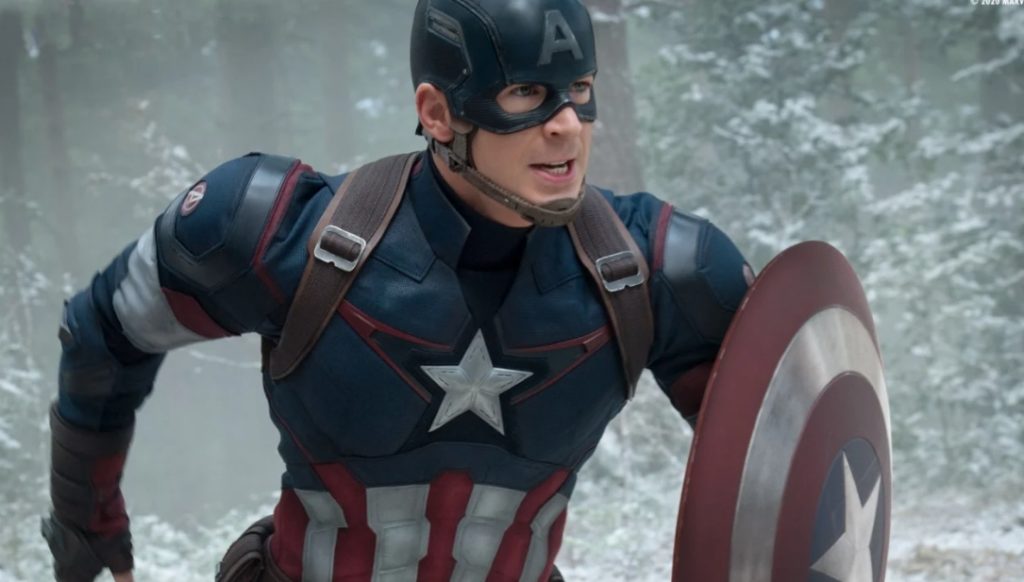 L'acteur Chris Evans dans le costume de Captain America, bouclier à la main et entrain de courir