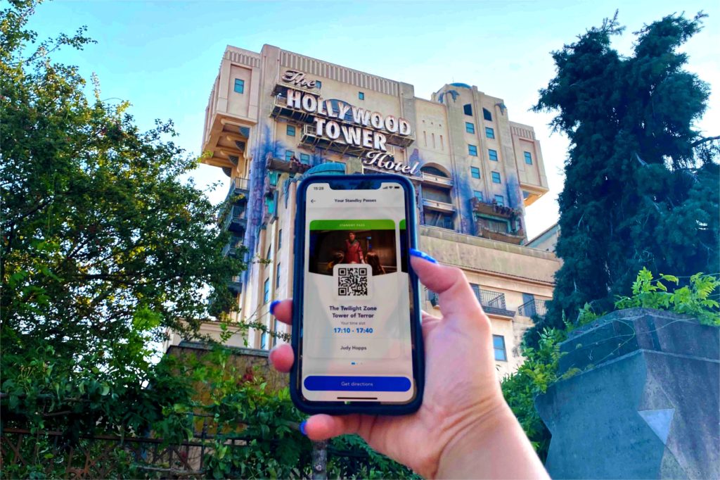 a disney first access on smartphone in front of the tower of terror 