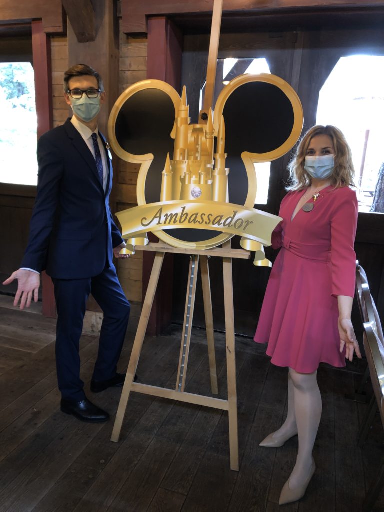 Les deux ambassadeurs de Disneyland Paris prennent la pose devant le logo géant