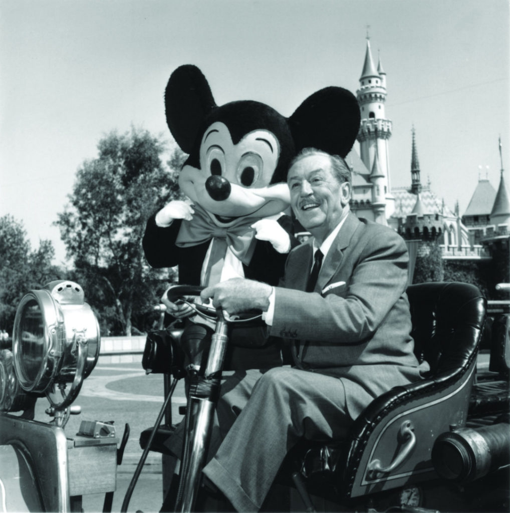 Walt Disney with Mickey at Disneyland in a car.